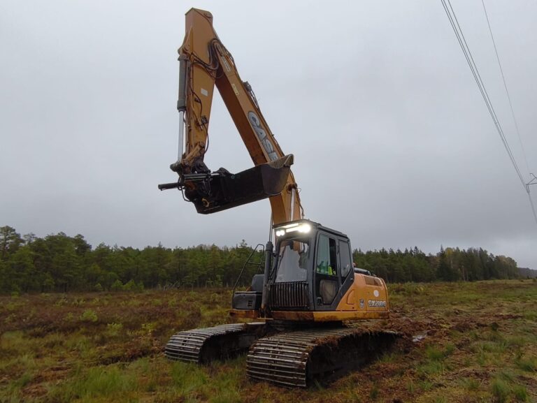 Ekskavaator teostamas kaevetöid ja pinnasetöid maastikul.